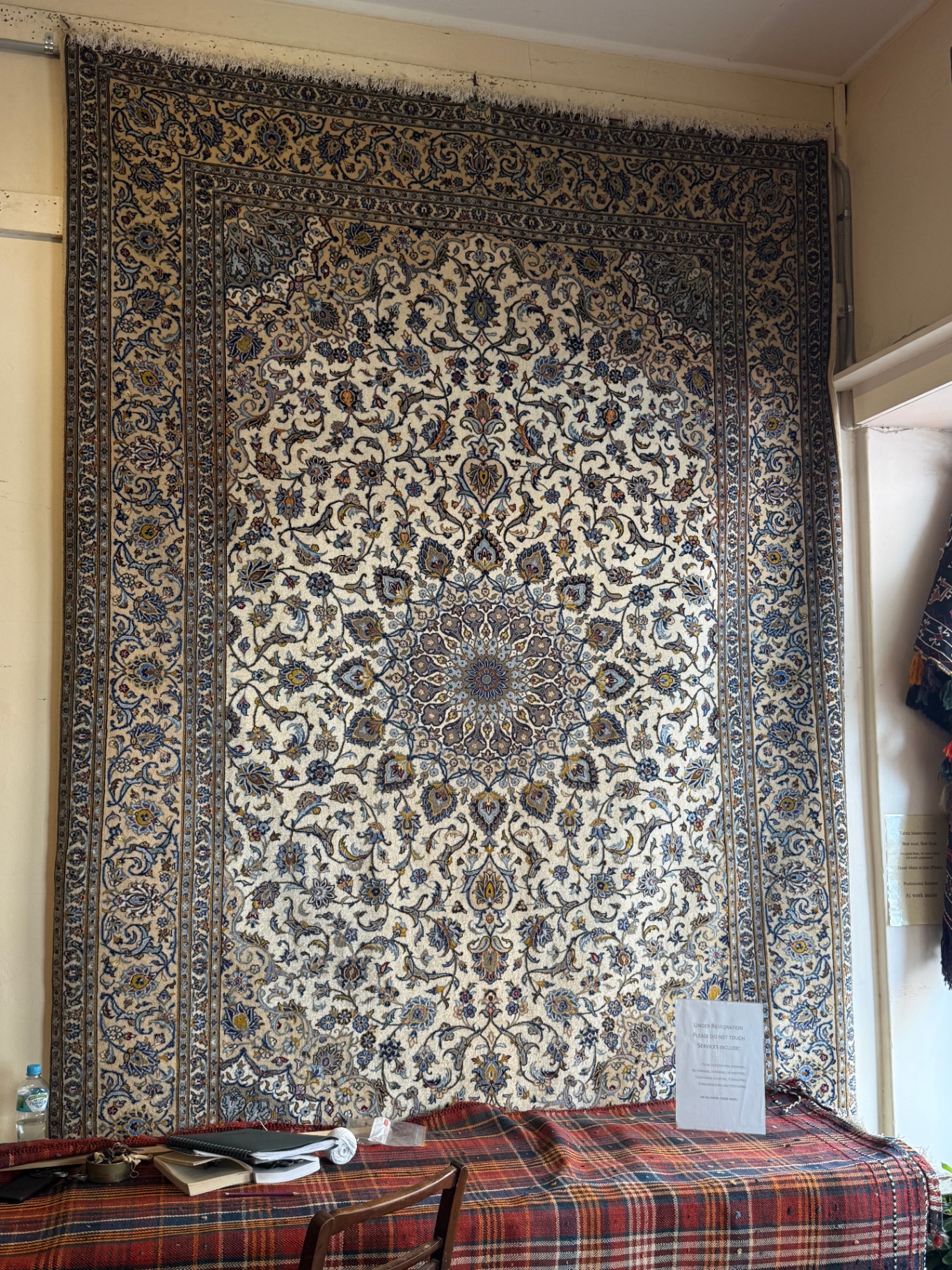 Antique Tabriz Persian rug displayed in a gallery
